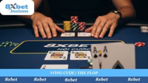 A 16:9 aspect ratio, photorealistic, point-of-view (POV) shot from a player's perspective. The player's two "hole cards" (e.g., Ace of Spades, King of Spades) are seen in the foreground. In the mid-ground, the "Flop" (three community cards) has just been dealt face-up on the 8xbet-branded table. The "Pot" (nồi cược) of chips is visible in the center. Tense, strategic atmosphere, cinematic lighting, shallow depth of field focusing on the Flop.